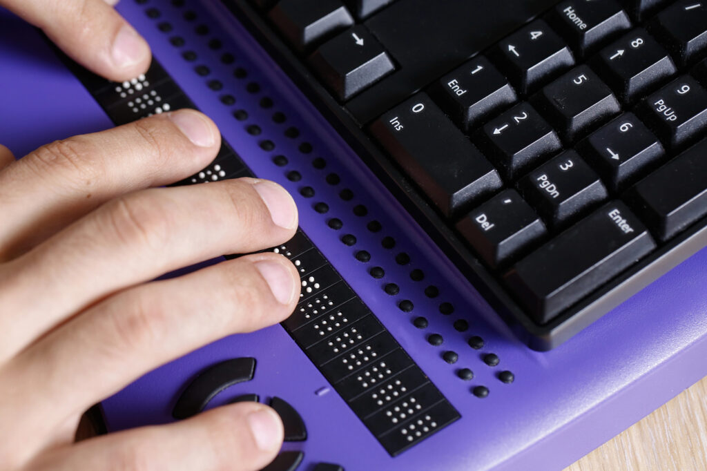 Blindenschrift vor Tastatur.