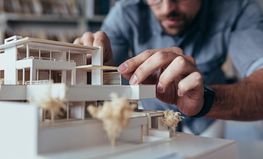 Nahaufnahme eines Architekten, der ein Modell bearbeitet.