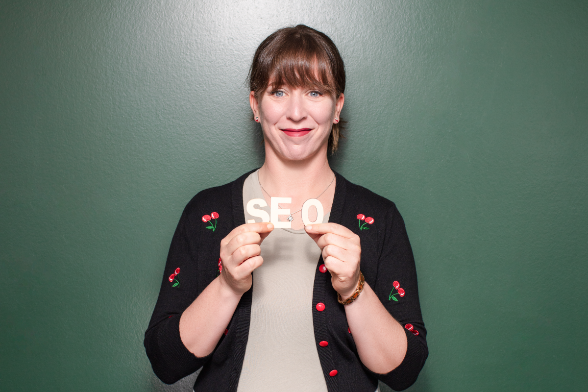 Kirschwerk Gründerin Nina Kirsch hält SEO Buchstaben vor sich.